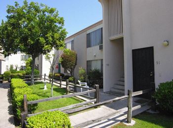 An apartment building with a yard and a wooden fence
